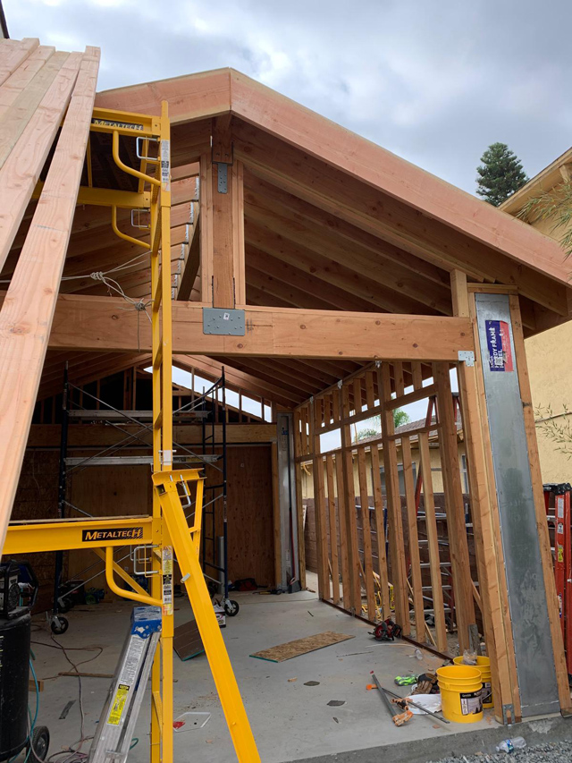 House frame with roof installation in progress.