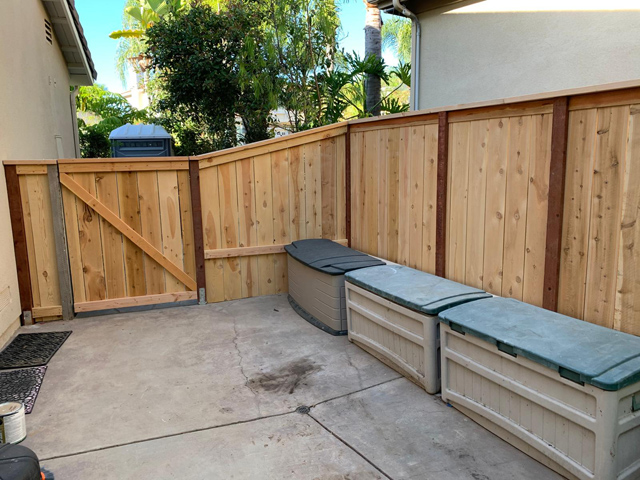 Sturdy wooden yard fence with a functional door for easy access.